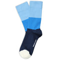 A pair of color-blocked crew socks with a light blue upper section, a medium blue middle section, a dark navy heel and toe, and a white foot sole, shown on a plain white background.